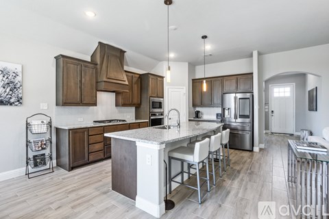 A modern kitchen with a center island and stainless steel appliances.
