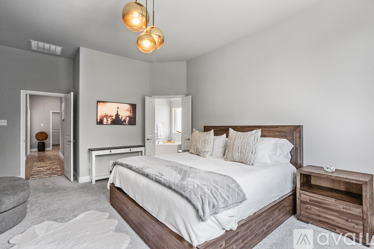 A bedroom with a large bed and a painting on the wall.