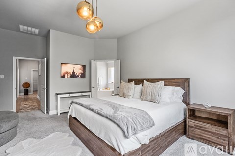 A bedroom with a large bed and a painting on the wall.