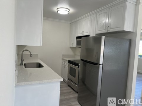 A modern kitchen with stainless steel appliances and white cabinets.