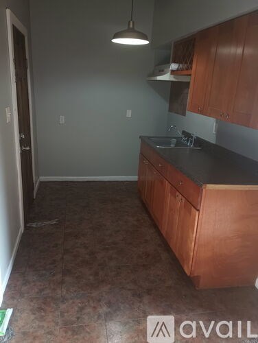 A kitchen with brown cabinets and a black countertop.
