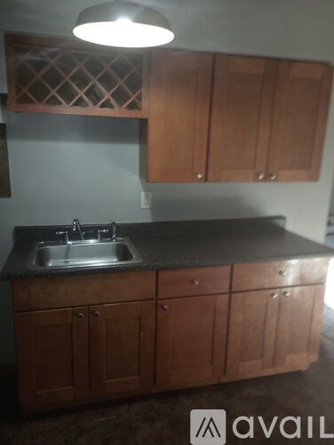 A kitchen with brown cabinets and a black countertop.