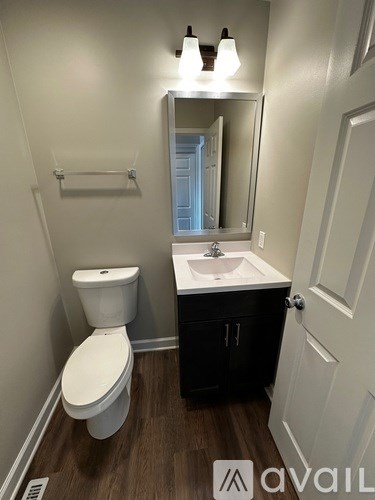 A white toilet sits next to a sink in a small bathroom.