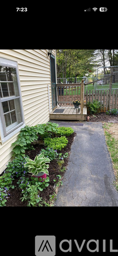 A small garden with a wooden deck and a metal fence.