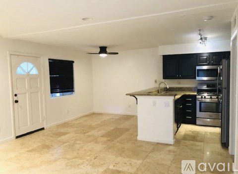 A kitchen with a white fridge and black cabinets.