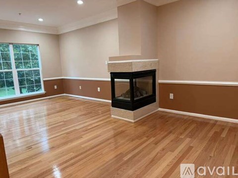 A living room with a fireplace and wooden floors.
