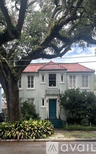 A white house with a red roof and a green door.
