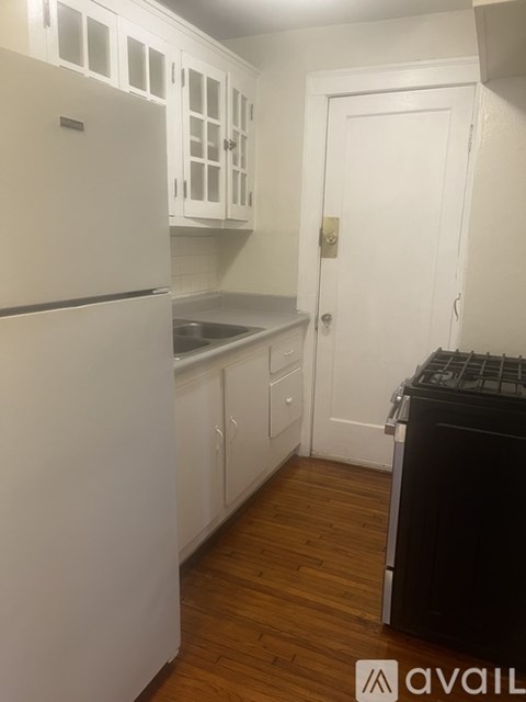 A kitchen with white appliances and cabinets.