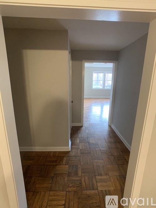 A hallway with wooden floors and white walls.