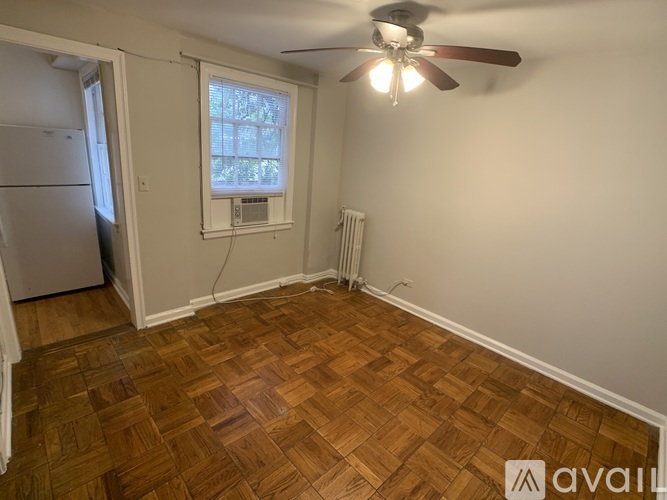 A room with a ceiling fan and a window with blinds.
