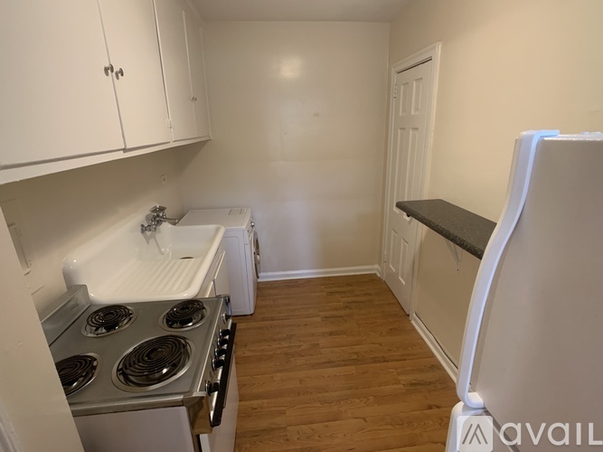 A kitchen with white cabinets and a stove top oven.