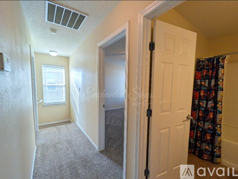 A room with a carpeted floor and a door leading to another room.