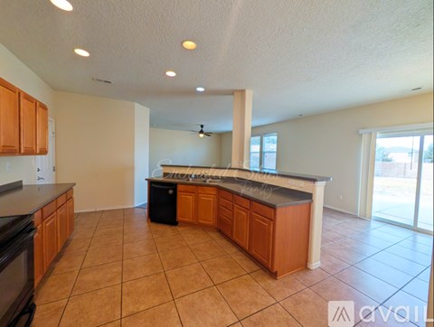 A kitchen with wooden cabinets and a black dishwasher.