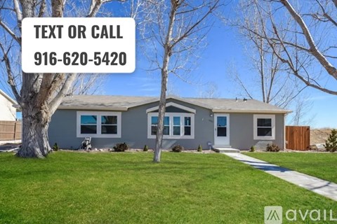 A house with a tree in front and a sign that says "TEXT OR CALL 916-620-5420".