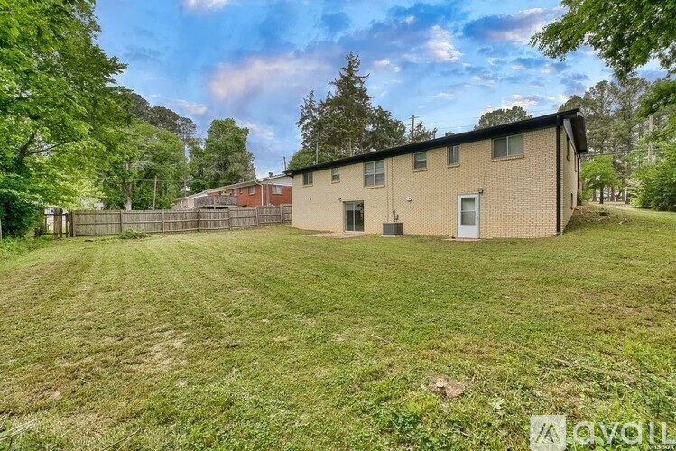 A house with a fence and trees in the background.