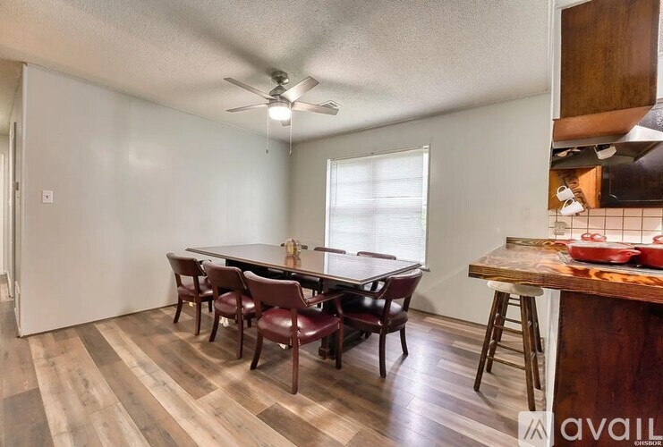 A dining room with a wooden table and chairs.