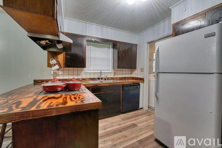A kitchen with a wooden countertop and a stainless steel refrigerator.