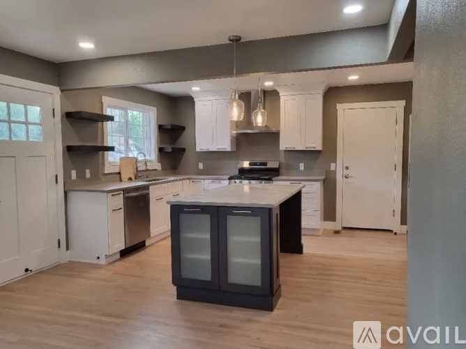 A modern kitchen with a large island and stainless steel appliances.