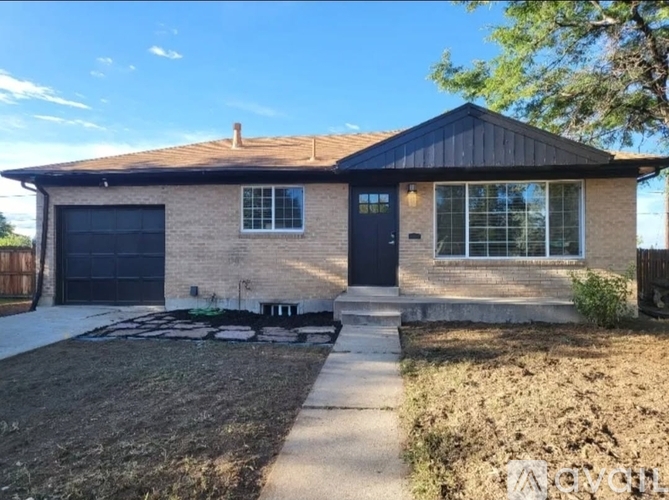 A house with a black garage door and a brick exterior.