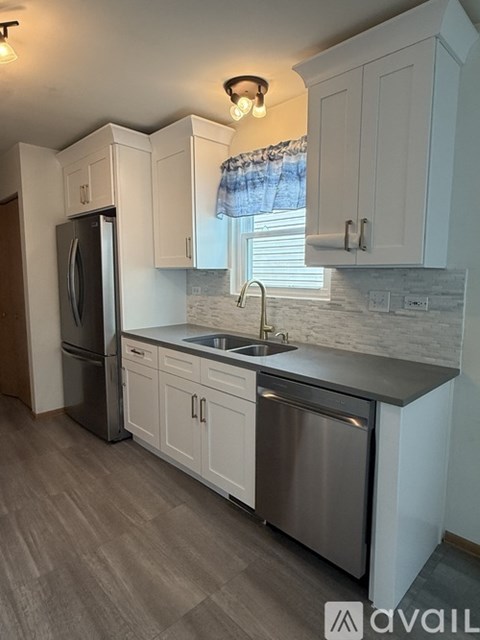 A kitchen with white cabinets and a stainless steel dishwasher.