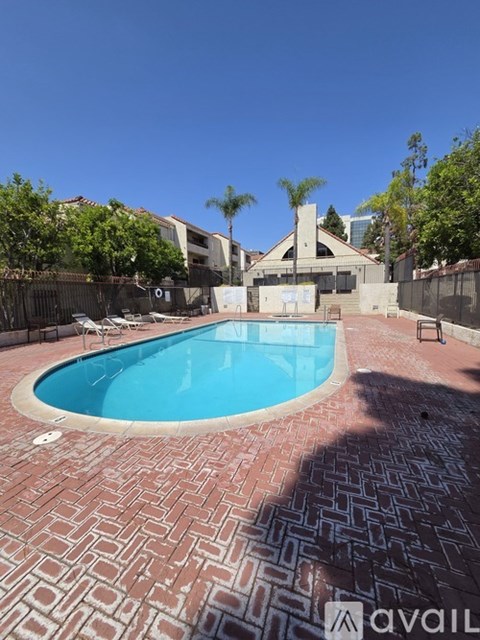 A pool surrounded by a brick patterned floor.