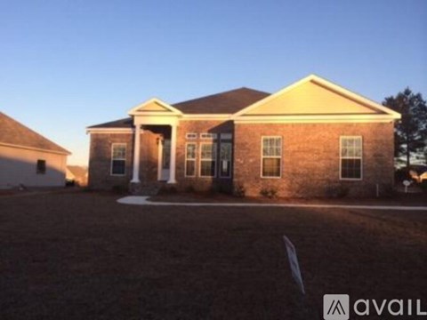 A house with a brick facade and a pitched roof is shown.
