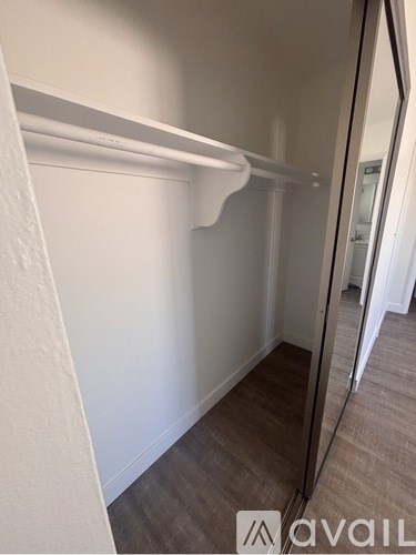A white closet with a mirror on the door.