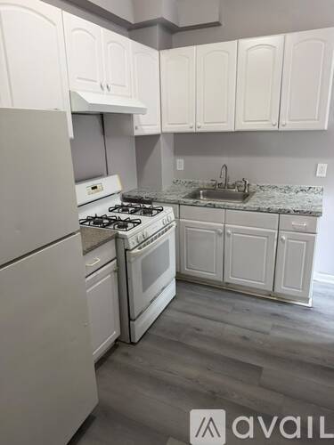 A kitchen with white cabinets and a stove top oven.