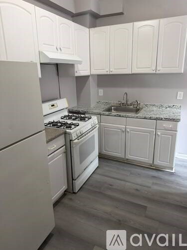A kitchen with white cabinets and a stove top oven.