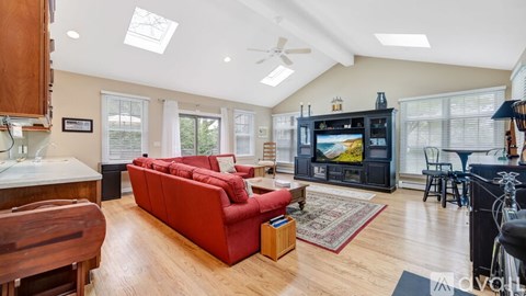 A living room with a red couch and a television.