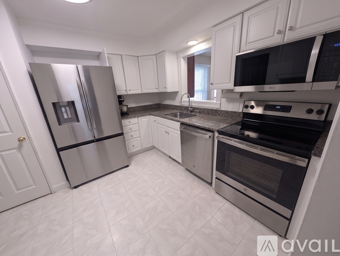 A kitchen with white cabinets and stainless steel appliances.