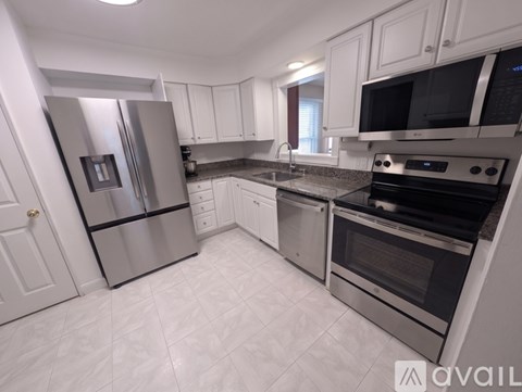 A kitchen with white cabinets and stainless steel appliances.