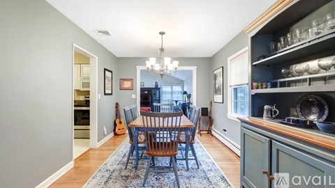 A dining room with a wooden table and chairs.
