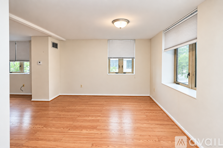A room with wooden flooring and a window with blinds.
