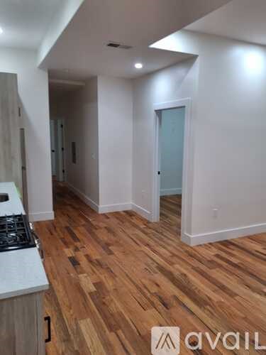 A room with wooden flooring and white walls.