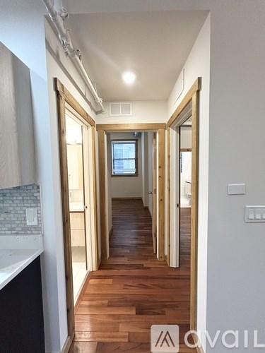 A long hallway with wooden floors and white walls.