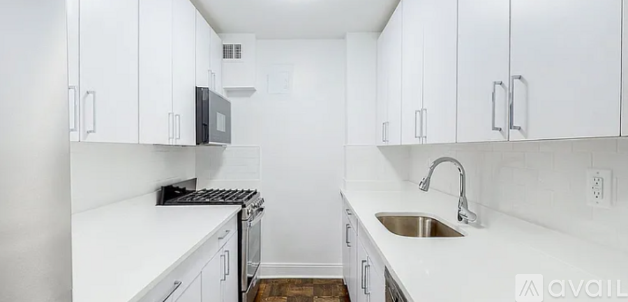 A kitchen with white cabinets and a sink.