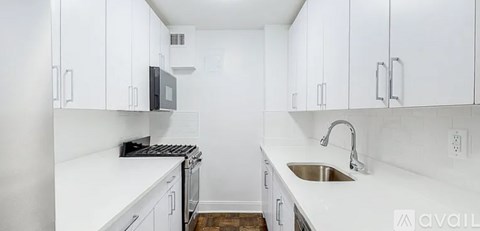 A kitchen with white cabinets and a sink.