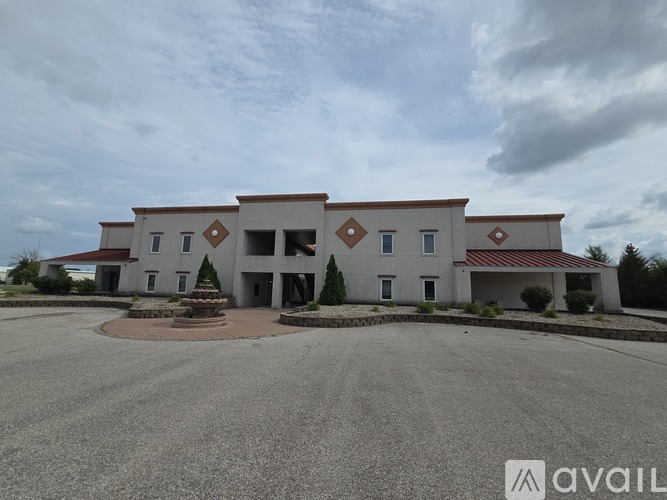 A large building with a circular driveway in front of it.