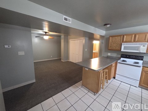 A kitchen with white appliances and wooden cabinets.