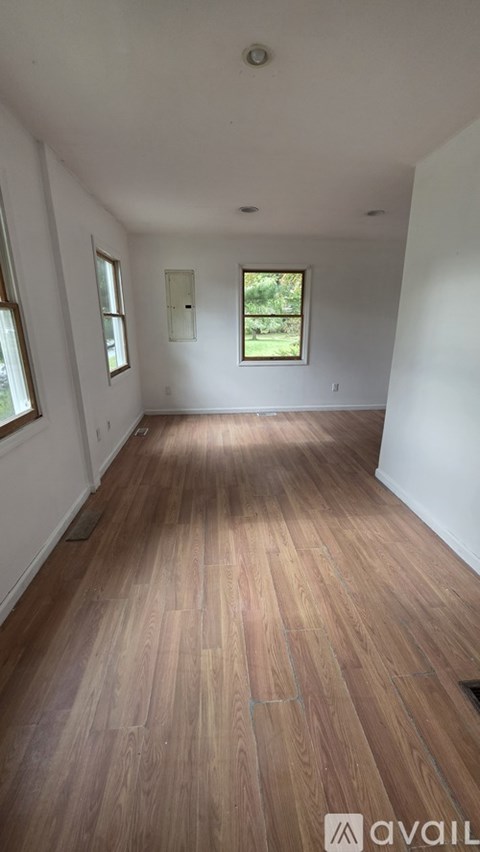 A room with wooden flooring and white walls.