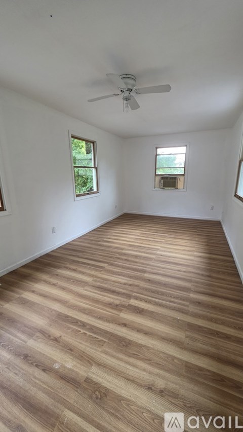A room with wooden flooring and a ceiling fan.