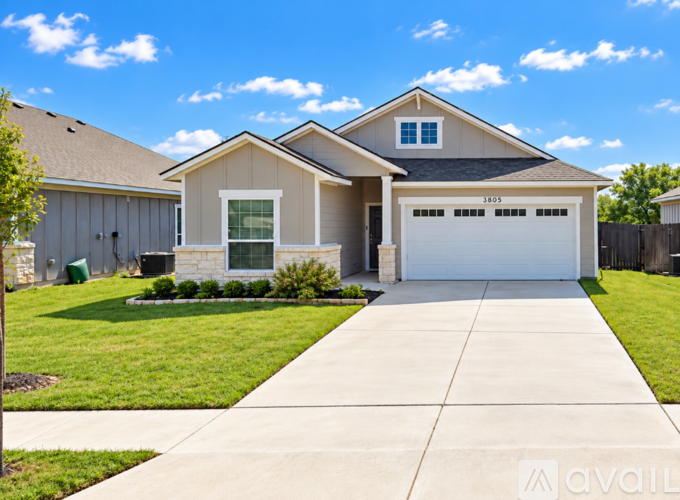 A house with a garage and a driveway in front of it.