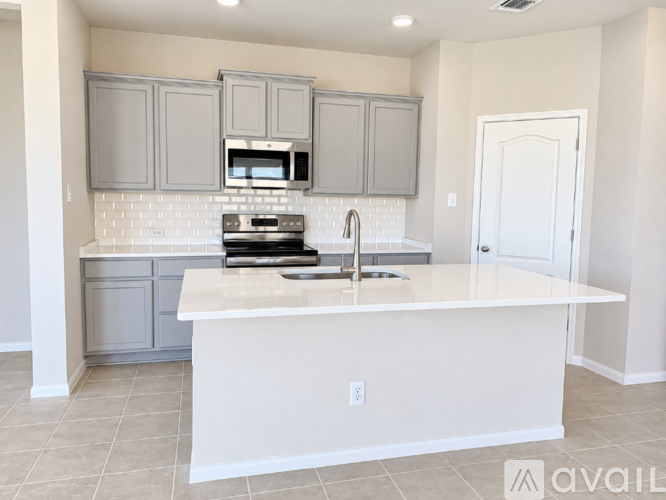 A kitchen with a white countertop and grey cabinets.