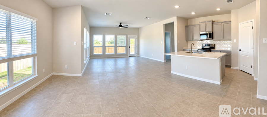 A spacious kitchen with a white island and a ceiling fan.