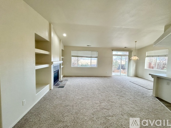 A spacious living room with a carpeted floor and a large window.