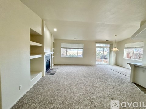 A spacious living room with a carpeted floor and a large window.