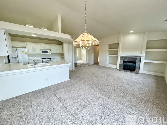 A spacious living room with a fireplace and built-in shelves.