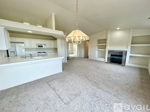 A spacious living room with a fireplace and built-in shelves.