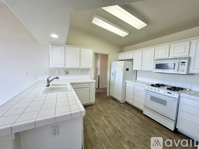A kitchen with white cabinets and appliances.